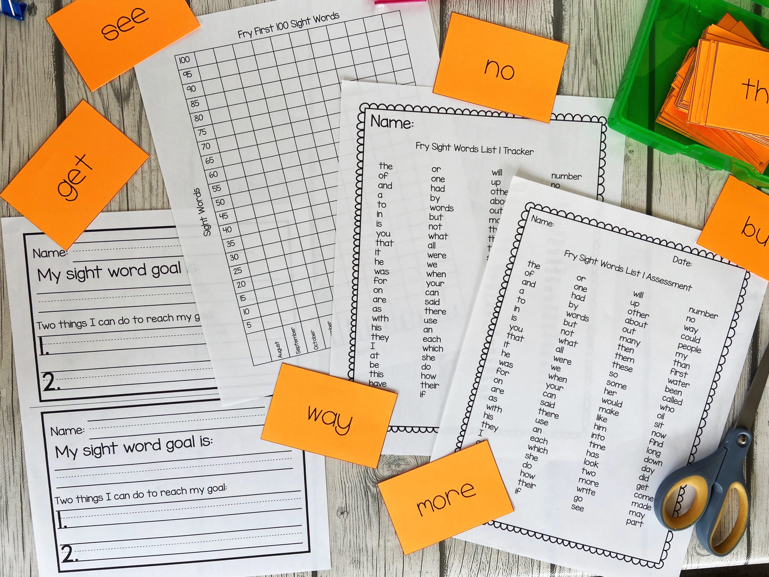ACS_0180 Orange word cards scattered around word lists and tracking pages for sight words.
